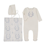 Baby outfit set with onesie, blanket, and bonnet featuring floral patterns on a white background.